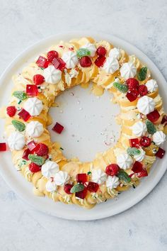 a white plate topped with a cake covered in whipped cream and fruit toppings on top of it