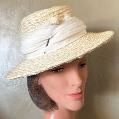 This Beautiful 1950s' Cream Colored Straw Hat Consists Of A Medium Height Crown Surrounded By A Medium Brim. The Weaving Of The Straw Is Beautiful And Is Softer Than Other Hats Of The Era. There Is A Draped Matching Color Fabric Band Around The Crown, And A Thick Hairpin With A Little Ball Head Made Of The Same Straw Is Inserted At One Side Of The Front. There Is A Small Bow At The Back. Lebel: There Is An Illegible Printed Label On The Inside Hatband, Which Most Likely Is A Consumer Protection Label. This Is An Authentic Piece Of Fashion History! This Hat Is In Wonderful Vintage Condition & Has Been Lovingly Preserved Among Over 1300 Vintage Hats We Have Collected For 40+ Years. Feathers Classic Fitted Cream Boater Hat, Vintage Straw Hat For Kentucky Derby, Vintage Beach Hat, Vintage Straw Hat With Short Brim, Vintage Hats For Summer Vintage Events, Fitted Vintage Hats For Vintage Fashion, Vintage Boater Hat With Curved Brim For Garden Party, Vintage Boater Hat For Garden Party With Curved Brim, Vintage Adjustable Boater Hat For Formal Occasions