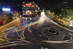 an aerial view of a busy city street at night with light streaks on the road