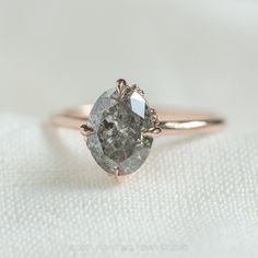 a close up of a diamond ring on a white cloth