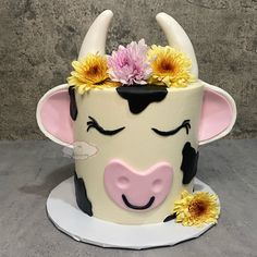 a cake decorated to look like a cow with flowers on its head and horns sticking out