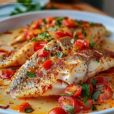 a white bowl filled with fish and tomatoes