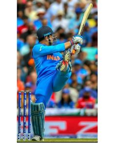 a man swinging a bat at a ball in front of a stadium full of people