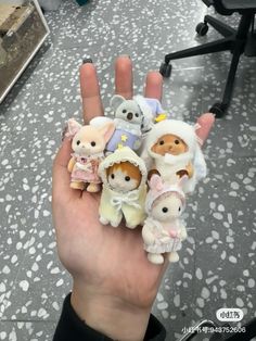 someone is holding their hand full of small stuffed animals