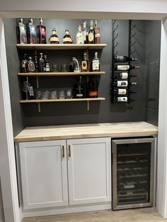 an empty wine cellar with bottles and glasses on the shelves, in a home bar