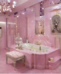 a pink bathroom with chandelier, vanity and bathtub in the middle of it