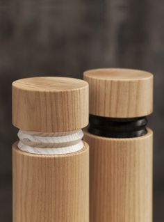 two wooden containers with black lids and white string on the top one is made out of wood