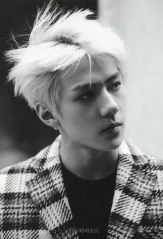 black and white photo of a young man with blonde hair wearing a checkered jacket