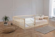 a baby's bed in the corner of a room with a potted plant next to it