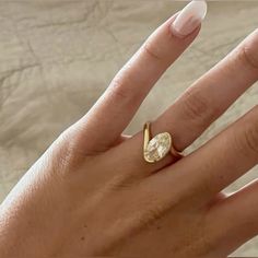 a woman's hand with a yellow diamond ring on top of her left hand