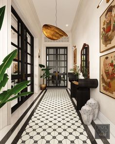 a hallway with black and white tile flooring and artwork on the walls, along with potted plants