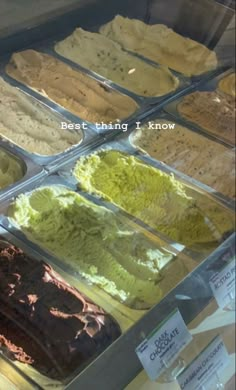 an assortment of ice creams in trays on display