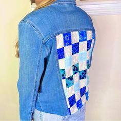 the back of a woman's jean jacket with blue and white squares on it