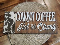 a sign that says cowboy coffee, hot and strong on the side of a table