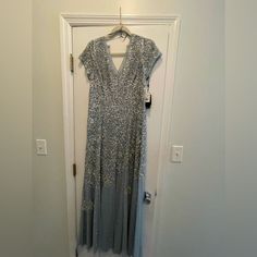 New With Tags. Size 12. Silver Gala Evening Dress, Elegant Silver Maxi Evening Dress, Silver Maxi Dress For Evening, Silver Maxi Dress For Formal Occasions, Elegant Silver Embellished Maxi Dress, Silver Maxi Gown For Prom Season, Formal Silver Maxi Dress, Silver Embellished Dress For Gala, Formal Silver Sequined Gown