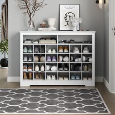 a white shoe rack with shoes on it in a living room next to a door