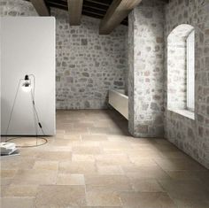 an empty room with stone walls and flooring