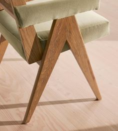 a wooden chair with green upholstered seat and back cushion on a hard wood floor