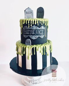 a three tiered cake with green icing and tombstones on the top layer