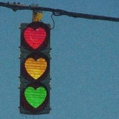 a traffic light with three hearts on it's red, yellow and green lights