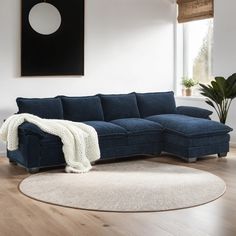 a living room with a blue sectional couch and white rug on the wooden flooring