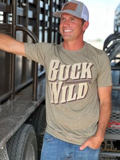 Buck Wild Graphic Tee by Texas True Threads Casual Brown T-shirt For Outdoor, Khaki Crew Neck T-shirt For Outdoor, Casual Khaki T-shirt For Outdoor, Khaki Short Sleeve T-shirt With Letter Print, Khaki T-shirt With Letter Print, Short Sleeve, Khaki Graphic Tee With Graphic Print, Green Crew Neck T-shirt With Lettering, Elsie De Wolfe, Gifts For Hubby