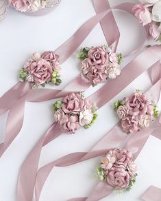 some pink flowers and ribbons on a table