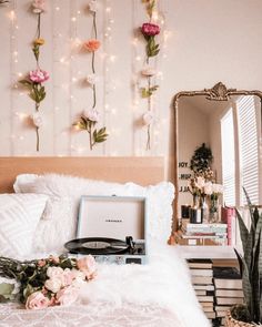 a record player sitting on top of a bed next to a mirror and flower decorations