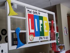 a sign that says the game of life is displayed in front of an open window