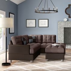 a living room with blue walls and a large sectional couch in front of a fireplace