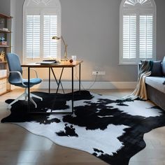 a black and white cowhide rug in a living room