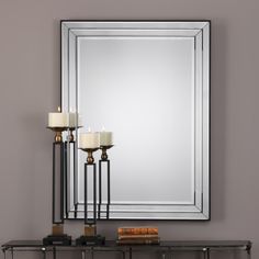 a mirror and some candles on a table