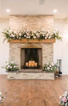 the fireplace is decorated with flowers and candles for an elegant touch to the wedding ceremony