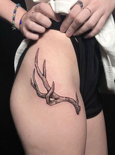 a woman's thigh with a tattoo of a deer antelope on it