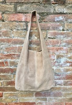 LARGE tote leather bag in light BEIGE, partially closed by a ZIPPER at the top. Slouch bag in genuine SUEDE leather. Soft suede bag. NOT LINED. Large enough to fit most laptops,  tablets. books etc.  With the zipper it is only available in this beige shade and also in mustard yellow. 20 different colors available in a very similar model, with a suede pouch attached to the bag instead of the zipper.  Width : 42cm - 16,5 in Height at the center: 34 cm - 13, 5 inc Total height : 65,5 cm  - 26 inch This bag in different colors and other leather Bags by Good Times Barcelona:  https://www.etsy.com/shop/goodtimesbarcelona?section_id=18820154&ref=shopsection_leftnav_10 Also available  a matching light BEIGE suede bel as on the last picture (this listing is only for the bag, there is also a separat Tote Leather Bag, Slouch Bag, Leather Zipper Pouch, Slouch Bags, Suede Bag, Small Coin Purse, Bohemian Bags, Beige Bag, Suede Belt