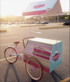 a pink and blue ice cream cart in the parking lot