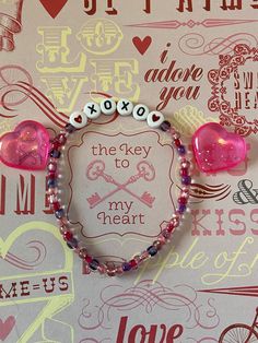 a close up of a bracelet on a wall with hearts and other things in the background