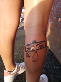 a person with a tattoo on their leg that has a drawing of a woman's face