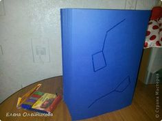 a blue book sitting on top of a wooden table next to a pile of books