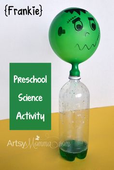 a green ball sitting on top of a bottle with an angry face painted on it