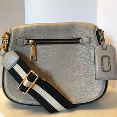 Marc Jacobs Gotham Saddle Grey Pebbled Leather Cross Body Featuring; Flat Top With Zip Around Exterior And Front Zip Pocket, Exterior Slot Pocket, Magnetic Snap Closure, Detachable Striped Shoulder Strap, Logo Luggage Tag, Internal Zip And 2 Wall Pockets, Gold Tone Hardware Throughout. Beautiful Soft Grey/Taupe Color. Euc With Tags Attached. Minimal Wear.. Gorgeous! Marc Jacobs Bag, Taupe Color, Flats Top, Pebbled Leather, Luggage Tags, Saddle, Gotham, Leather Crossbody, Camera Bag