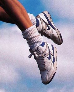 a person jumping high in the air on a skateboard with their feet up and shoes down