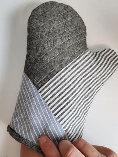 a hand holding a piece of fabric with stripes on it and the other side of the hat