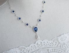 Blue Sapphire Necklace, Bridal Pearl/Sapphire CZ Necklace, Something Blue Necklace, Wedding Jewelry, Bridal Jewelry, Sapphire Pearl Necklace Materials: - 9mm rhodium plated blue sapphire and white cubic zirconia connectors  - rhodium plated over brass chain - white/Ivory Cream Swarovski pearls - 15x24mm Blue Sapphire cubic zirconia teardrop pendant The listing is for one necklace.  ❤❤ ❤BRIDAL and BULK ORDERS DISCOUNT ❤ ❤❤  5% Discount : 2 items (Use Coupon Code - 5DISCOFF) 10% Discount : 3-5 items (Use Coupon Code - 10DISCOFF) 15% Discount : 6 items and more (Use Coupon Code - 15DISCOFF) Here is a helpful link how to use the coupon code discount: www.etsy.com/help/article/350 The necklace will arrive packaged ready for gift giving in a delicate white jewelry box with a silver ribbon. Match Sapphire Necklace Wedding, Unique Wedding Jewelry, Blue Wedding Jewelry, Jewelry Sapphire, Blue Sapphire Necklace, Bridal Pearl Necklace, Bridal Choker, Pearl Necklace Vintage, Pearl Necklace Wedding