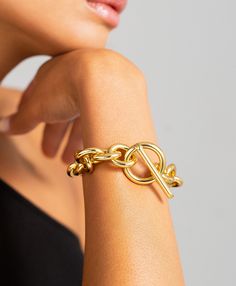 One for the maximalists, the Viveca is an eye-catching cable chain that speaks for itself. Vibrant and feminine, the name Viveca means 'alive' and this iconic piece echoes that feeling, the pièce de résistance on any wrist and a perfect day-to-night design. As bold as it is simple and finished with an oversized toggle clasp. Material: 18ct Gold Plated Brass. Dimensions: Chain Length 22.5cm Polished Chain Bracelet, Modern Gold Cable Chain Bracelets, Modern Gold Cable Chain Bracelet, Luxury Cable Chain Bracelet As Gift, Modern Gold-tone Chain Bracelet, Adjustable Modern Cable Chain Bracelet, Modern Adjustable Cable Chain Bracelet, Modern Gold-plated Bracelets With Cable Chain, Yellow Gold Metal Bracelets With Cable Chain