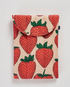 an orange and white bag with strawberries printed on the front, sitting on a white surface