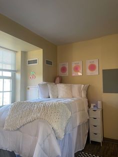 a white bed sitting in a bedroom next to a window