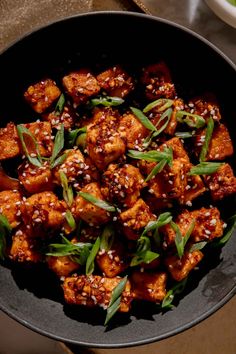 tofu with sesame seeds in a black bowl