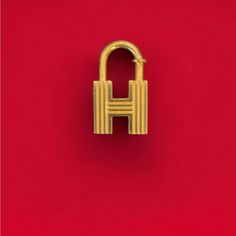 Tradition And Refinery Come Together In This Herms Bag Accessory. The Brand's Bags Are Often Fastened With A Set Of Keys And Padlock, Which Now Can Be Exchanged For This Engraved H-Motif Padlock Charm. This Cadena Lock Charm From Herms Is The Perfect Gift For Yourself Or A Friend. Herms Issued One Cadena Per Year Related To That Year’s Theme. Use This H Cadena From 2000 As A Lock On Your Birkin Or Kelly, On A Key Ring, Or As A Pendant! This Piece Is Perfect For The Herms Lover! The Gold Plated H Gold Shopping Bag With Lock, Luxury Hallmarked Gold Charms, Gold Logo Charm Bag Charm, Luxury Red Satchel With Gold-tone Hardware, Luxury Red Bag With Gold-tone Hardware, Hermes Accessories, Gold Bag, Branded Bags, Dog Hair