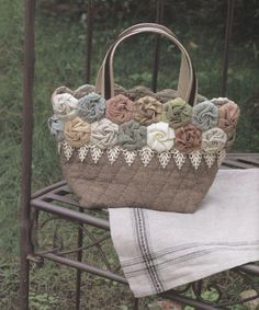 a handbag sitting on top of a metal rack next to a white cloth towel